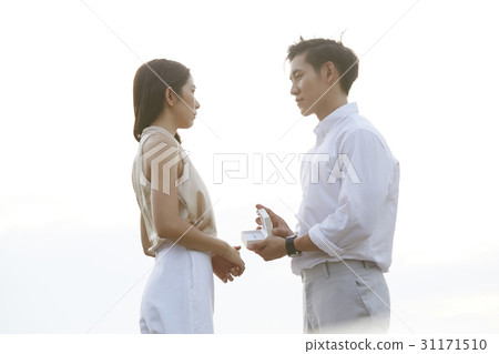 A man with an ring box is proposing to his girlfriend. 31171510