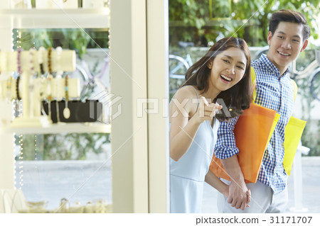 A girl is excited and pointing to items in a store for a happy man 31171707