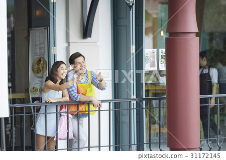 a couple is smiling and pointing to something in the lobby a couple is smiling and pointing to something in the lobby 31172145