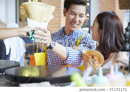 man and woman are smiling, buying food and looking at each other man and woman are smiling, buying food and looking at each other 31172171