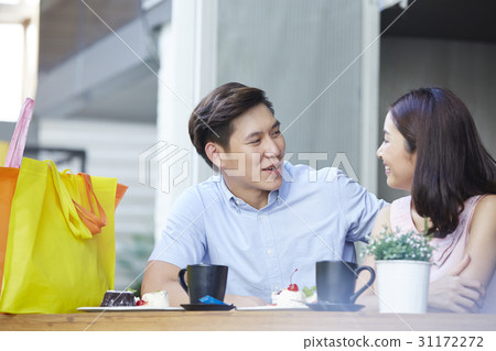a man and woman are sitting and happily taking in a coffee shop a man and woman are sitting and happily taking in a coffee shop 31172272