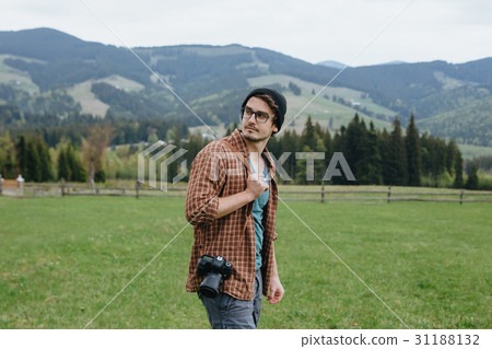 Man with camera in the mountains. Photographer. To 31188132