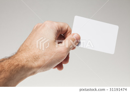 Male hand holds white empty card over gray 31191474