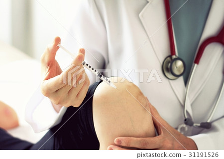 Doctor giving an injection to young woman patient Doctor giving an injection to young woman patient 31191526