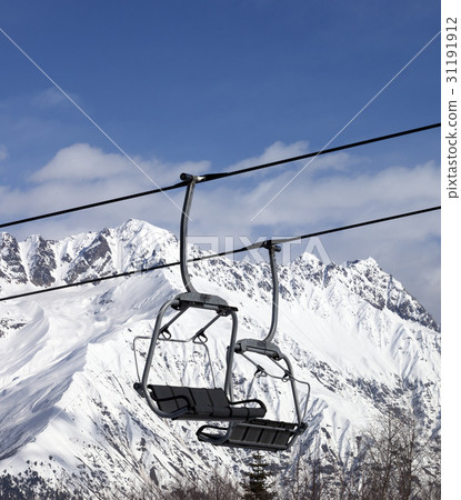 Chair lift in snowy mountains at nice sun day 31191912