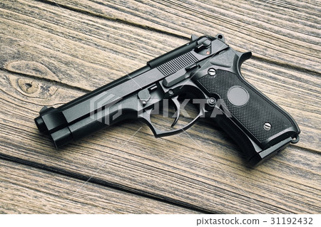 Handgun, 9mm pistol close-up on wooden background. Handgun, 9mm pistol close-up on wooden background. 31192432