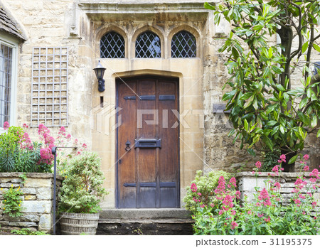 dark brown wooden doors in old house with garden 31195375