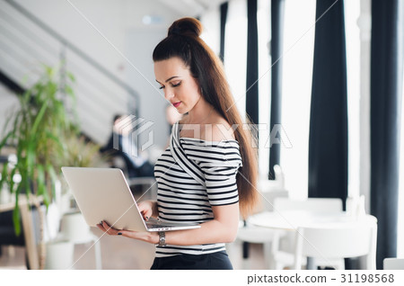 Charming female is using mobile phone and laptop Charming female is using mobile phone and laptop 31198568