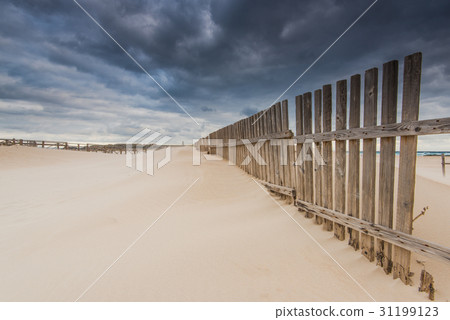 wooden fence on dunes and beach at storm weather wooden fence on dunes and beach at storm weather 31199123