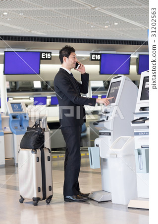 操作一台自動報到機器的商人在機場 31202563