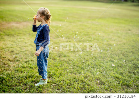 Little Girl Blowing Bubble at Grass Field Park Outdoor 31210184