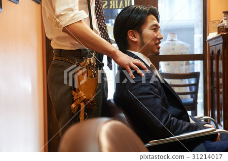 在造型方面與美髮師協商的男性顧客 在造型方面與美髮師協商的男性顧客 31214017