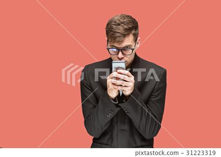 The young caucasian businessman on red background The young caucasian businessman on red background 31223319