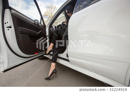 The woman is getting out of the car The woman is getting out of the car 31224919