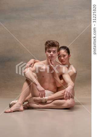 Couple of ballet dancers posing over gray 31225820