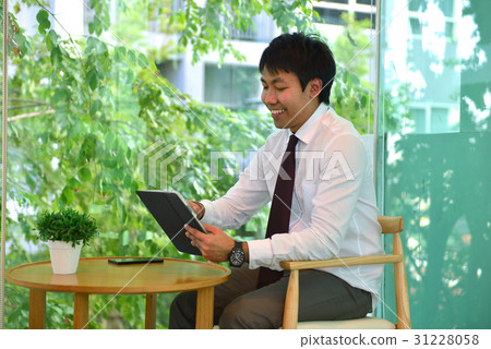 An Asian business man using a taplet, person smiling An Asian business man using a taplet, person smiling 31228058