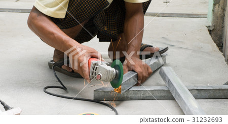 WORKER CUTTING STEEL WITH ELECTRIC WHEEL GRINDER WORKER CUTTING STEEL WITH ELECTRIC WHEEL GRINDER 31232693