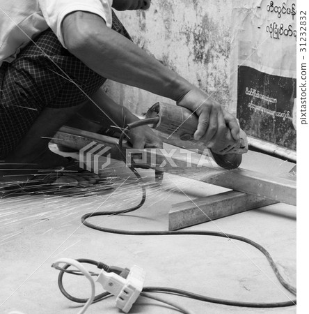 WORKER CUTTING STEEL WITH ELECTRIC WHEEL GRINDER 31232832