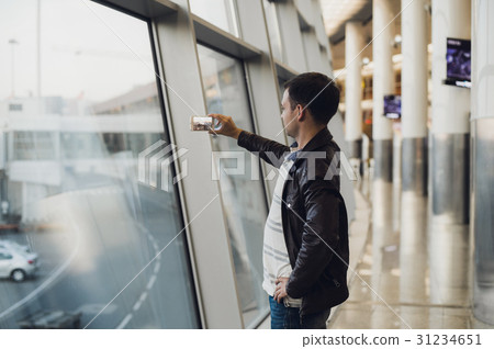 traveler with mobile phone at the airport taking traveler with mobile phone at the airport taking 31234651