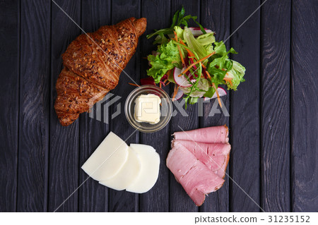 Croissant with ham, mozzarella, salad and butter Croissant with ham, mozzarella, salad and butter 31235152