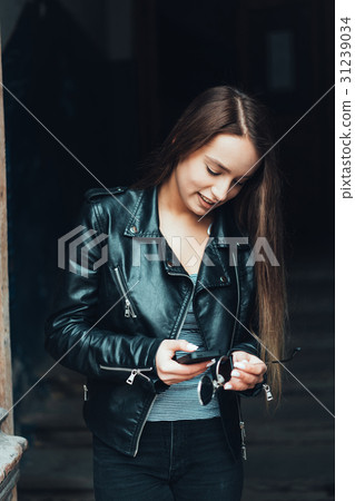 Beautiful girl in black jacket with smartphone Beautiful girl in black jacket with smartphone 31239034