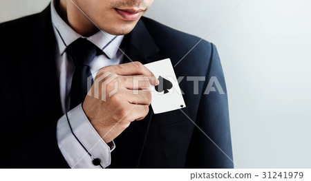 Businessman in black suit pulling ace spade card 31241979