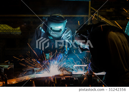 Team welders are welding in factory Team welders are welding in factory 31242356
