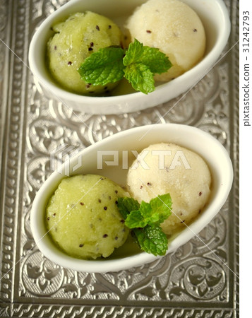Gelato silver tray of green & gold kiwi (vertical position high angle) 31242793