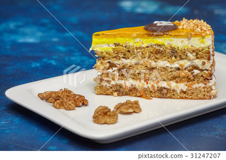 Piece of carrot cake with icing and walnut 31247207