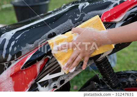 Female hand washing a motorcycle. 31247631
