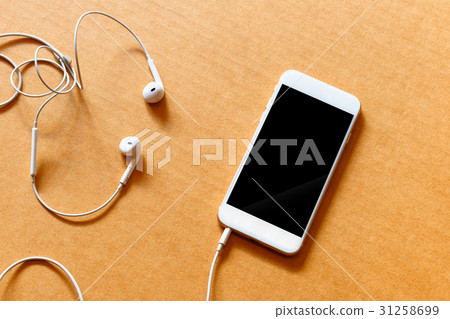 Blank white smartphone, and earphones on wooden Blank white smartphone, and earphones on wooden 31258699