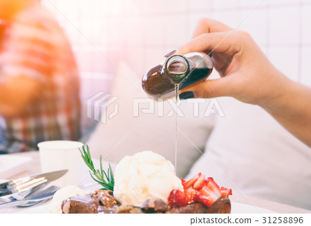 Close up woman pouring honey on honey toast. 31258896