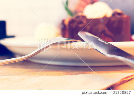 Close up fork and knife on dish with ice-cream. 31258897