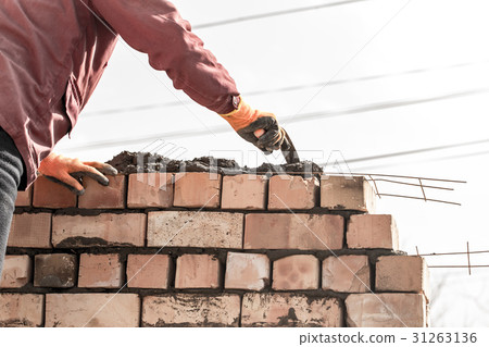 Worker builds a brick wall in the house Worker builds a brick wall in the house 31263136