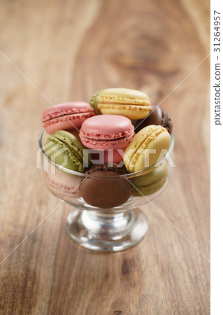 assorted macarons in glass bowl on wood table 31264957