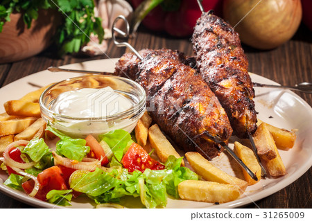 Grilled shish kebab served with fried chips 31265009