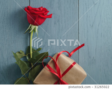 red rose with gift on blue wood table 31265022