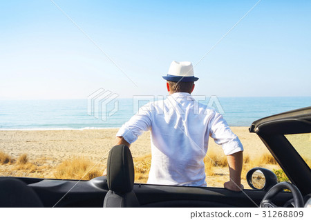 Man on summer beach near car looking to the sea Man on summer beach near car looking to the sea 31268809
