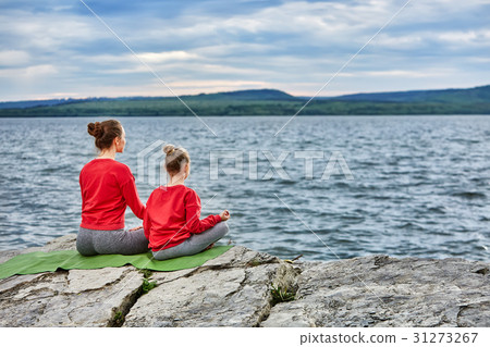 Rear view of mother and daughter practicing yoga Rear view of mother and daughter practicing yoga 31273267