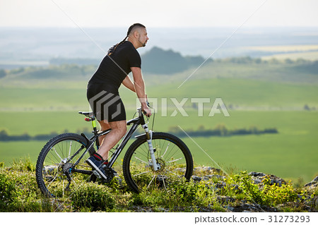 Cyclist standing with mountain bike on background Cyclist standing with mountain bike on background 31273293