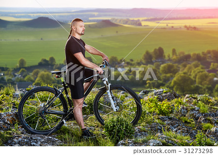 Cyclist standing with mountain bike on background Cyclist standing with mountain bike on background 31273298