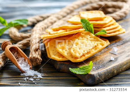 Crisp crackers and a wooden scoop with salt. 31273554