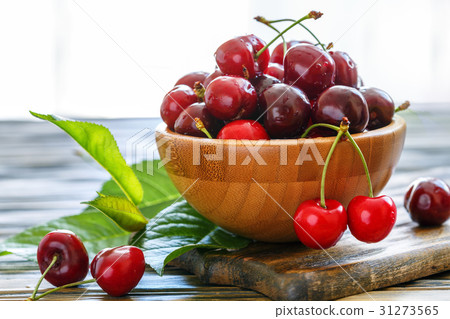 Ripe sweet red cherries in a wooden bowl. 31273565