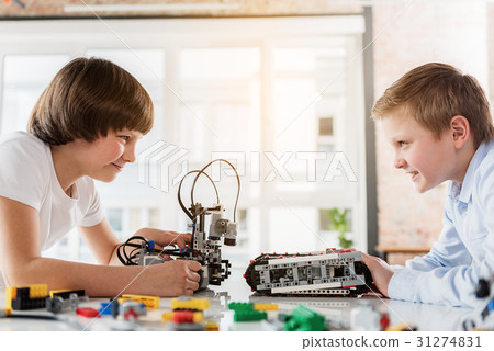 Cheerful male children playing with robotics 31274831