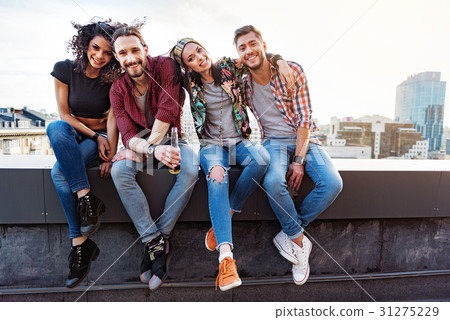 Joyful young people relaxing on rooftop terrace Joyful young people relaxing on rooftop terrace 31275229