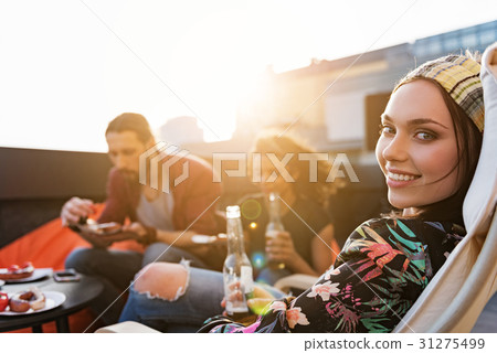 Cheerful young people relaxing on roof with food Cheerful young people relaxing on roof with food 31275499