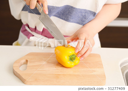 A woman cutting yellow paprika A woman cutting yellow paprika 31277409