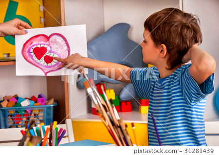 Child painting heart in art school class. Mother Child painting heart in art school class. Mother 31281439
