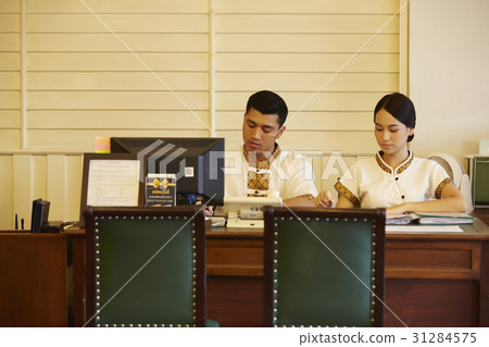 two receptionists are working in reception desk. 31284575
