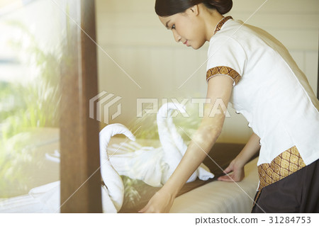 The maid is arranging swans made of towels on the bed in hotel. The maid is arranging swans made of towels on the bed in hotel. 31284753